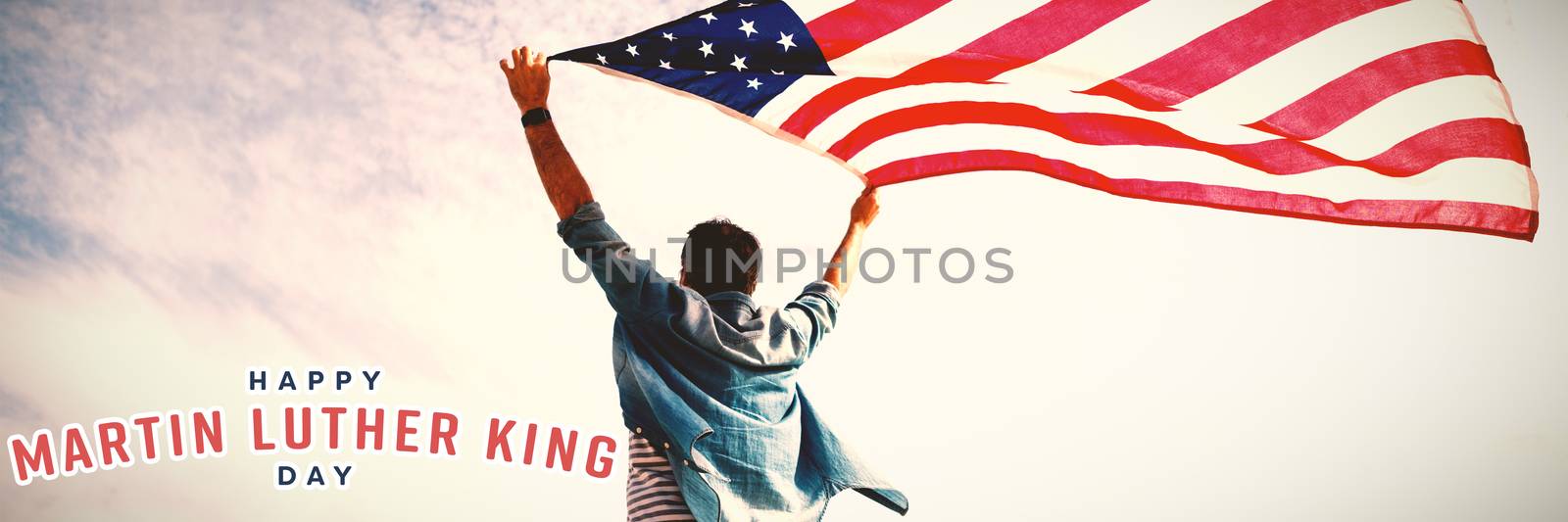 happy Martin Luther King day against low angle view of man holding american flag against cloudy sky