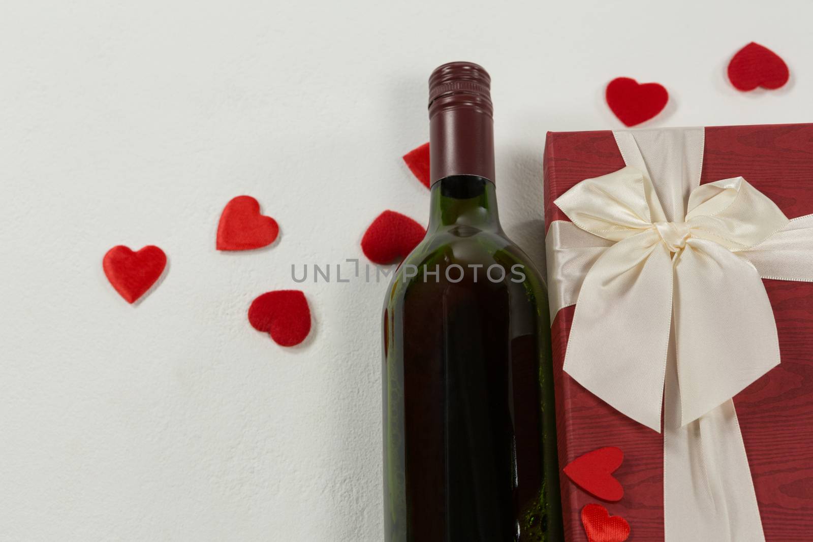 Close-up of wine bottle with valentine gift and decoration on white background