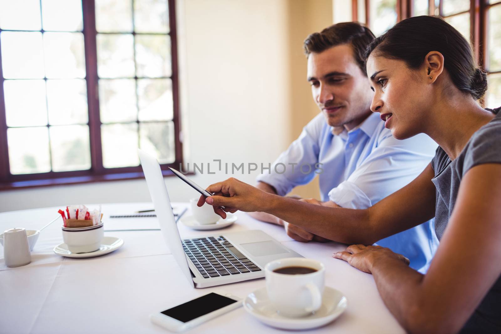 Business people discussing on laptop in restaurant