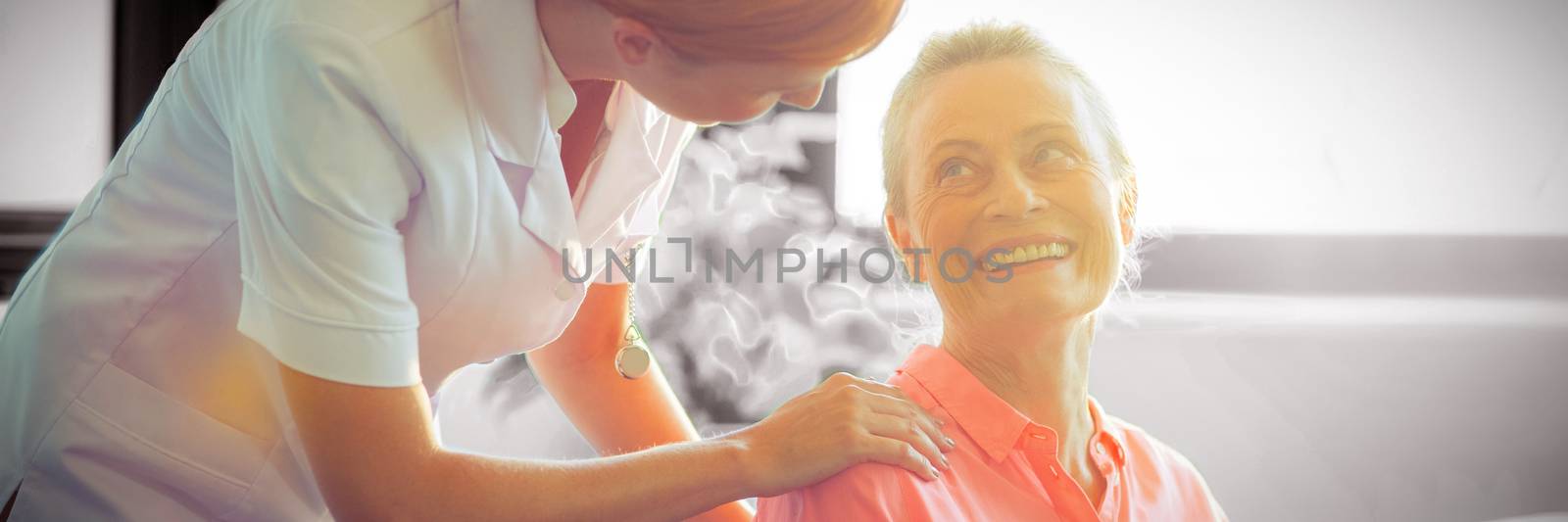 Female nurse consoling senior woman at home