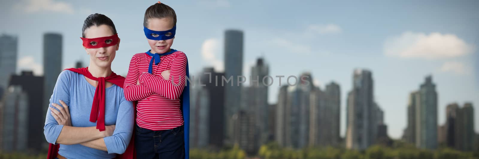 Mother and daughter pretending to be superhero against skyline at the river coast