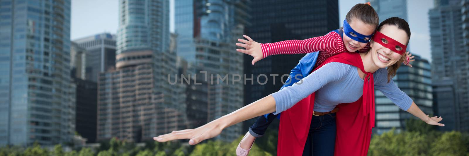 Mother and daughter pretending to be superhero against city