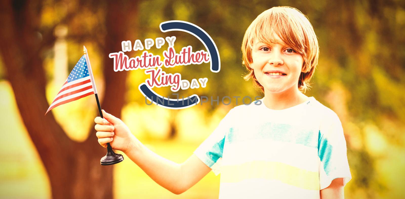 Portrait of cheerful boy holding American flag against happy martin luther king day