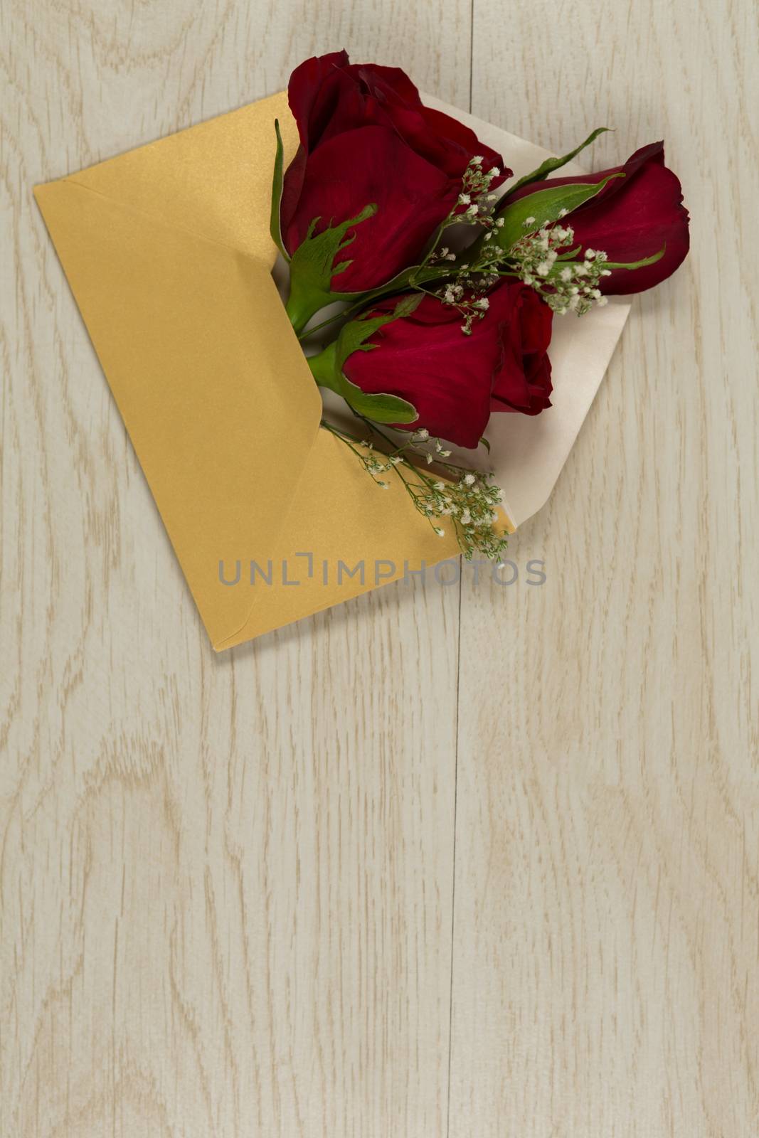 Rose bouquet in a envelope on wooden table