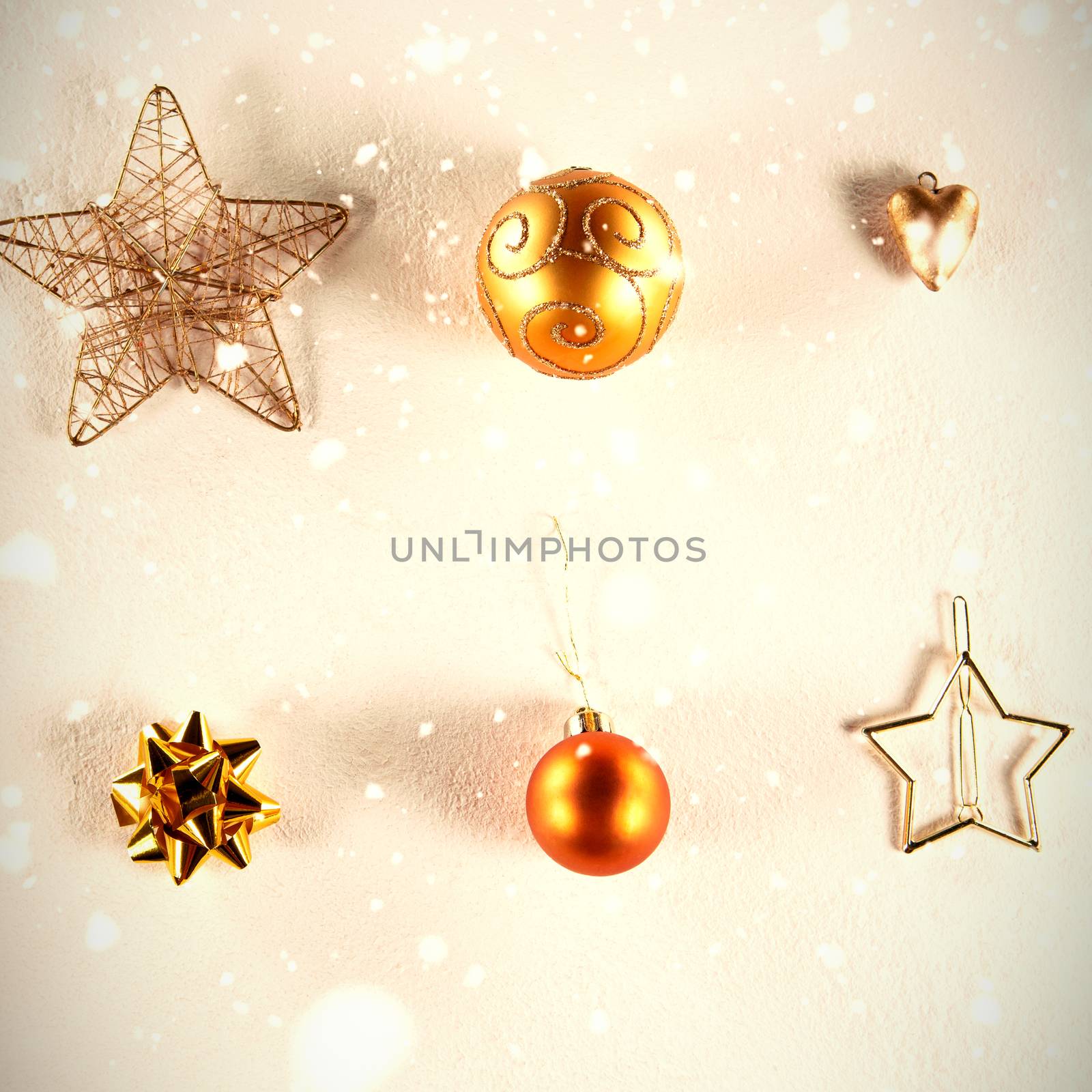 Snow falling against yellow and golden christmas ornaments