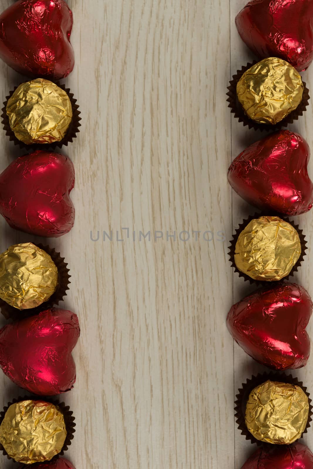 Close-u of chocolates and heart shape decorations arranged on wooden table