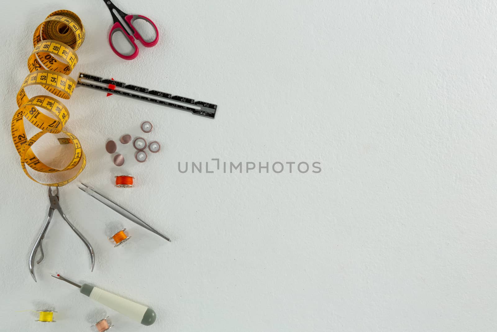 Overhead of thread rolls and various tools on white background