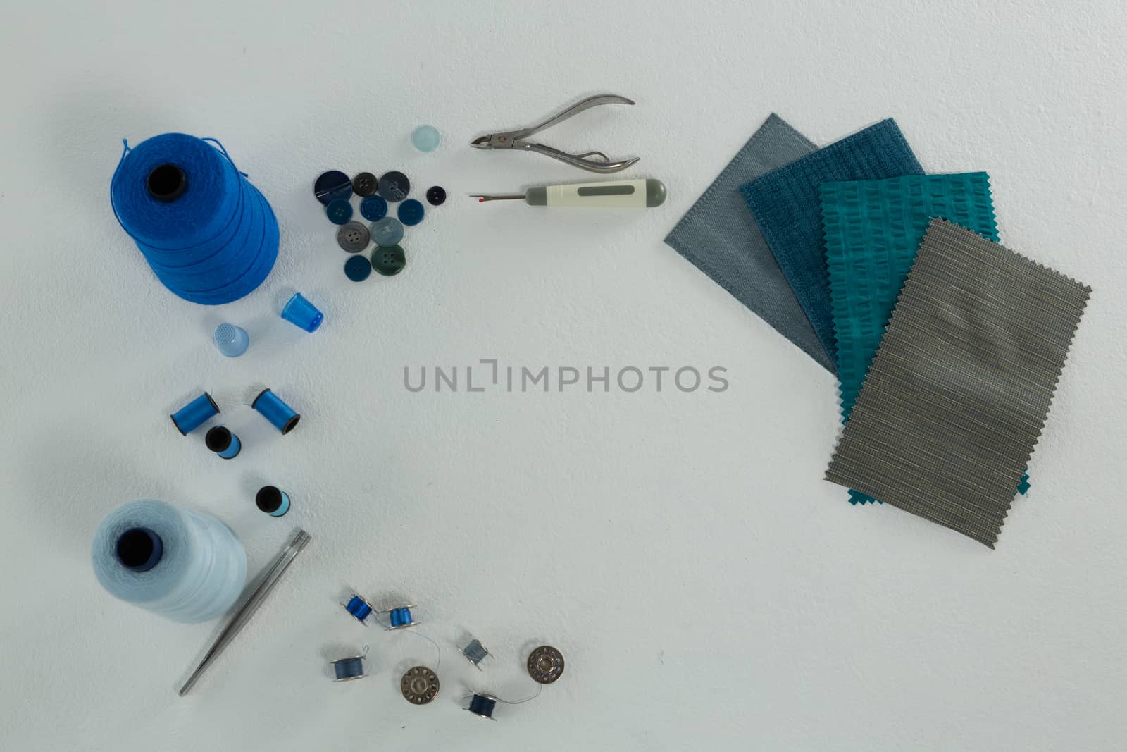 Overhead of thread rolls and various tools on white background