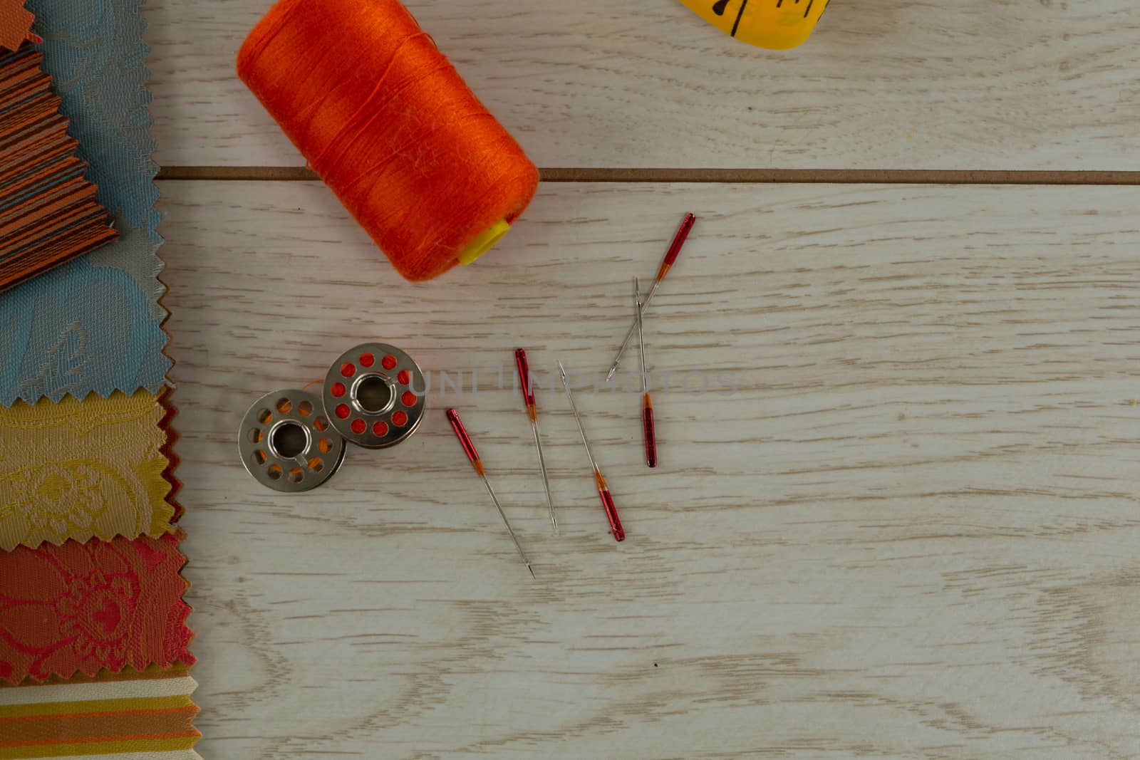 Close-up of textile, thread rolls and various equipments on a table