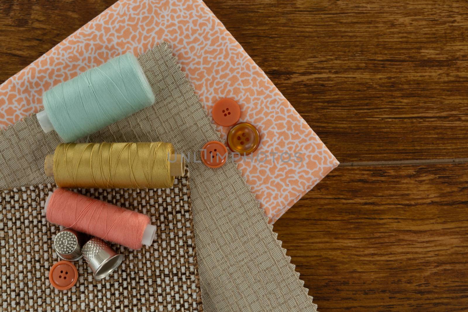Overhead of thread roll and various equipments on a table