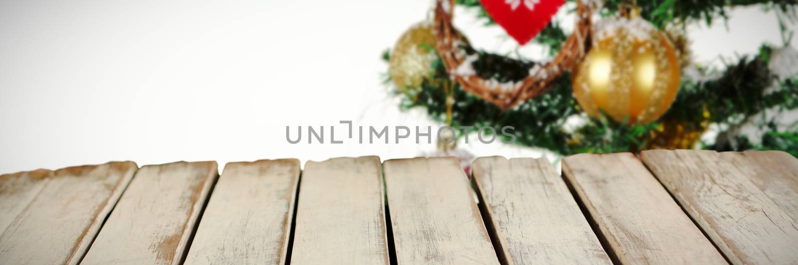 wooden boards against christmas tree decorated with ornaments