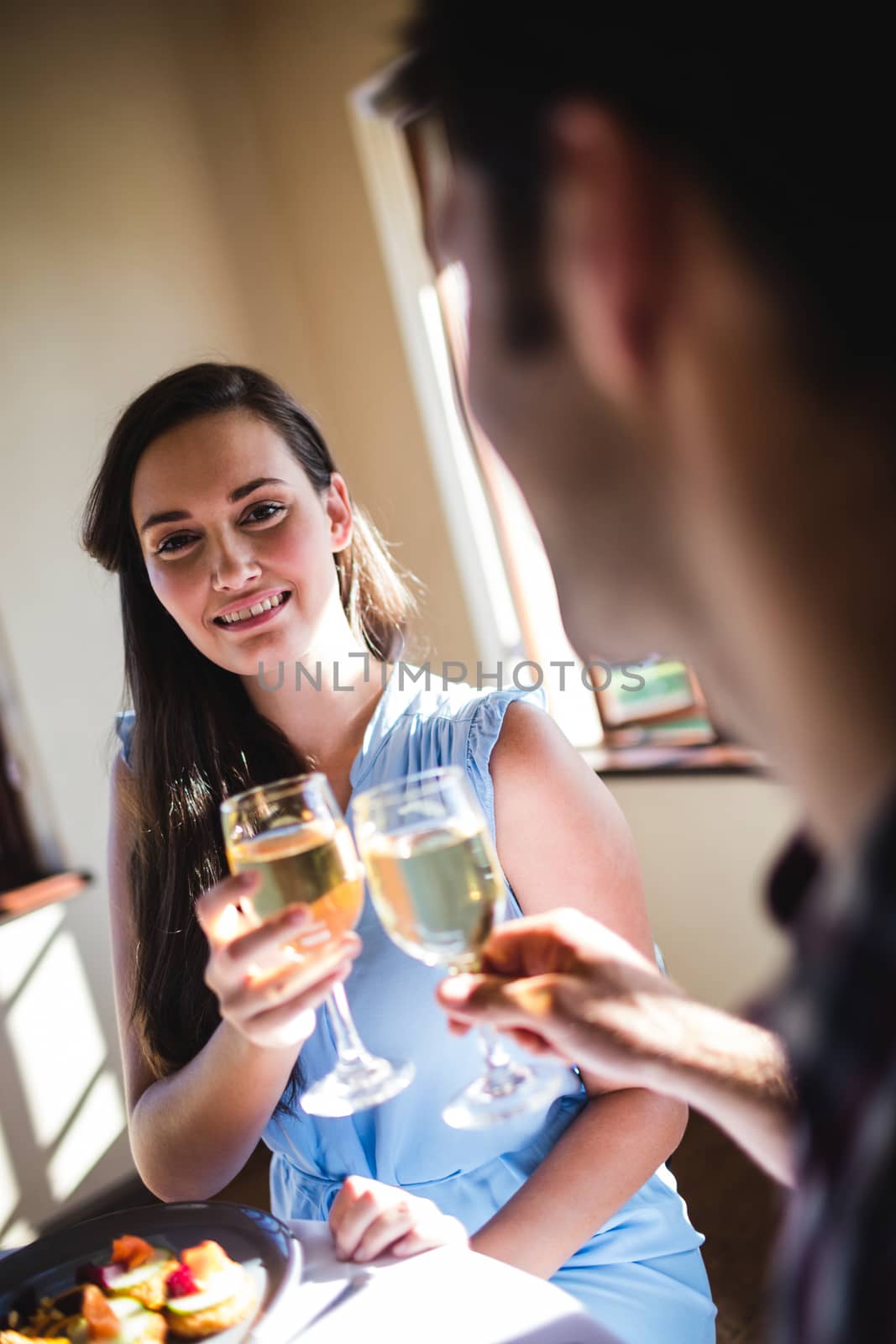 Young couple toasting white wine glass in restaurant