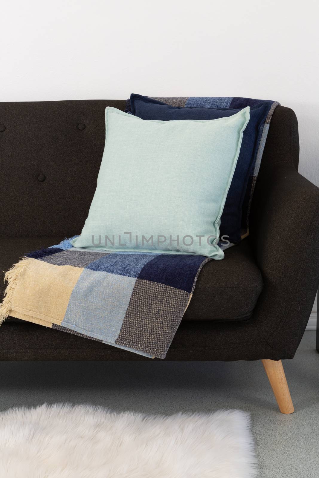 Close-up of cushions and blanket arranged on sofa
