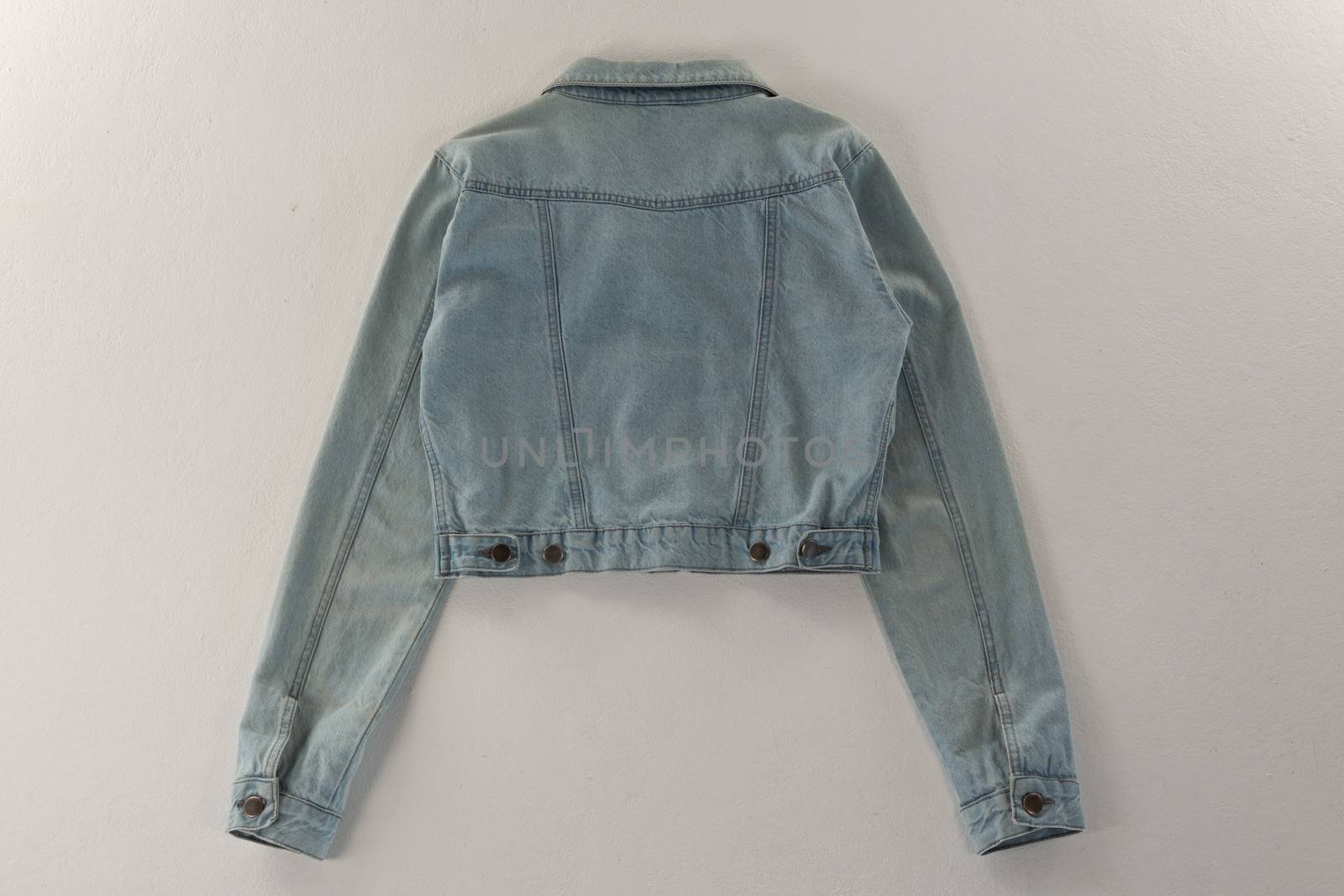 Close-up of denim jacket on white background