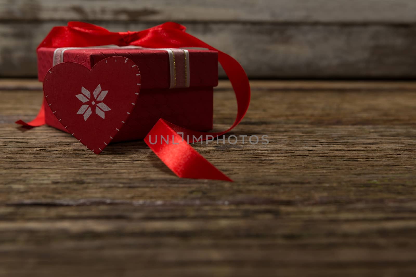 Close-up of heart shape decoration and gift on wooden plank
