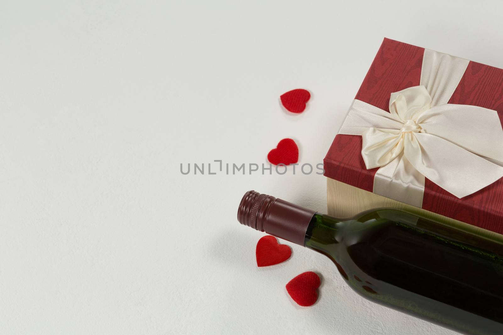 Close-up of wine bottle with valentine gift and decoration on white background