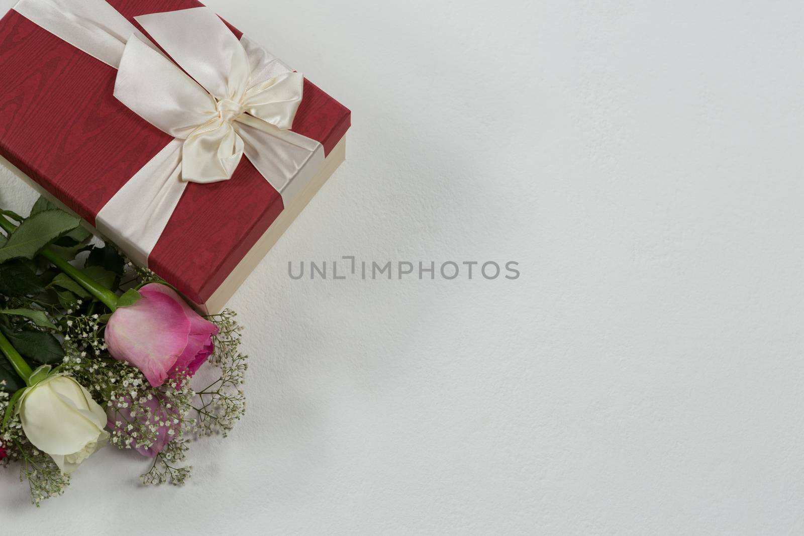 Close-up of flower bouquet and gift on white background