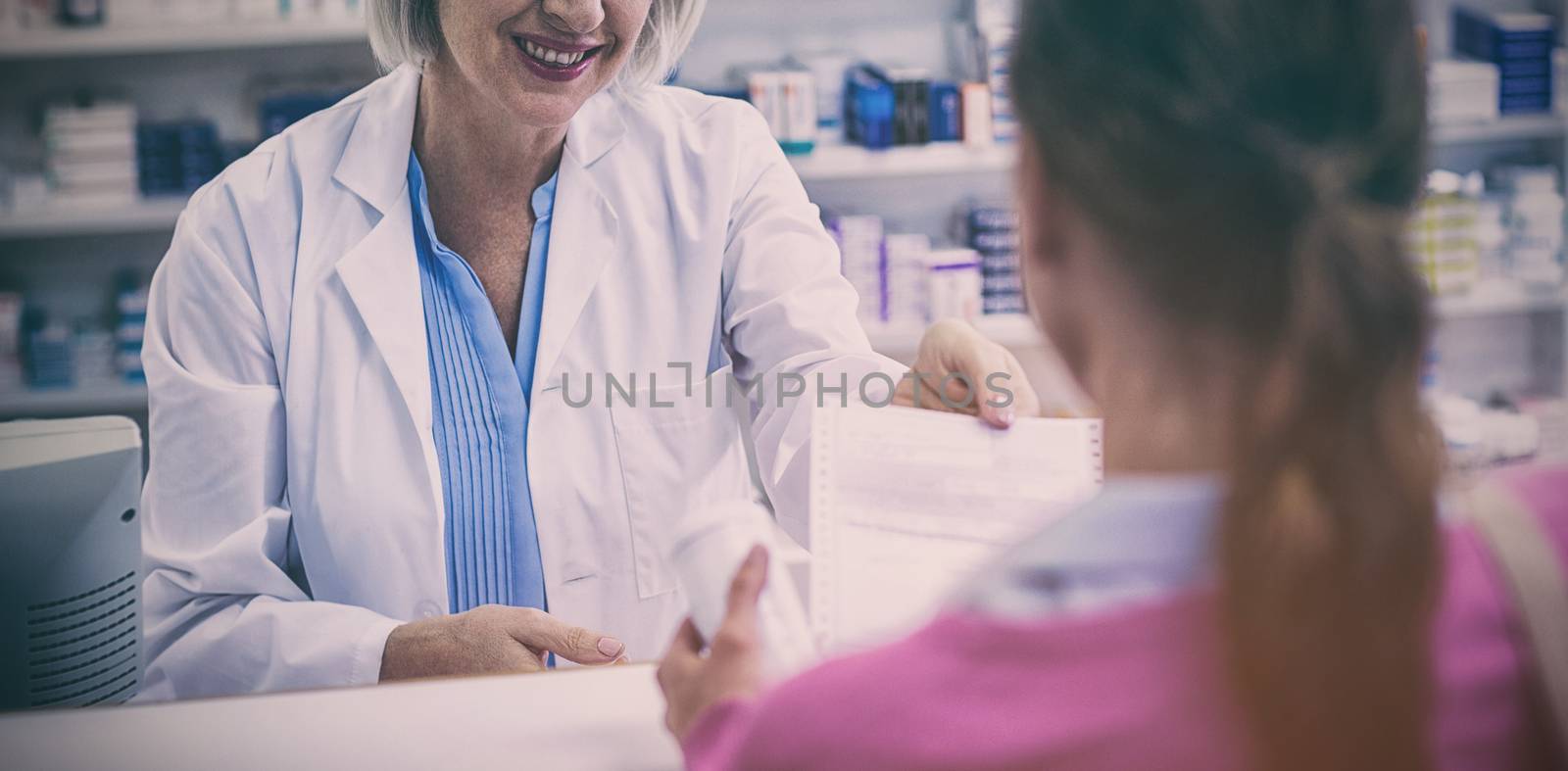 Pharmacist giving prescriptions of medicine to customer in pharmacy