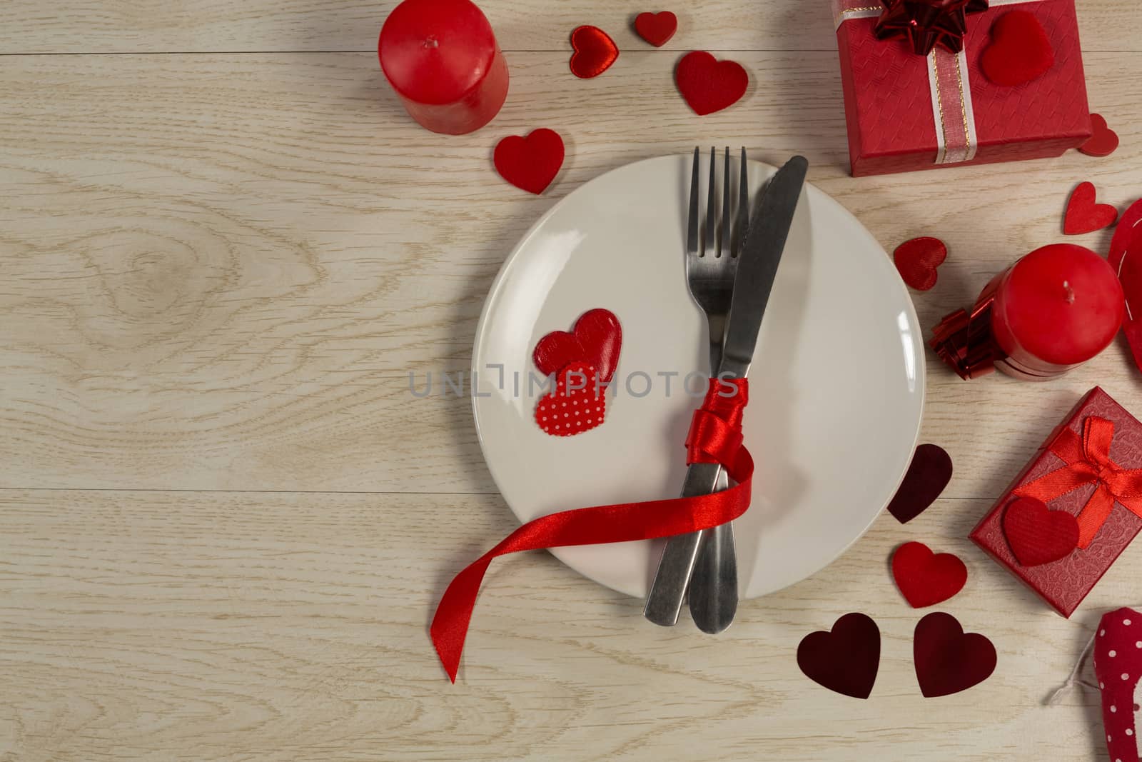 Gift boxes and heart shape decorations with cutlery on wooden table