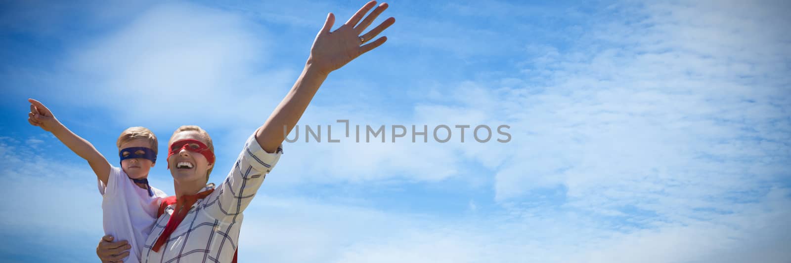 Mother and son pretending to be superhero against low angle view of cloudy sky 