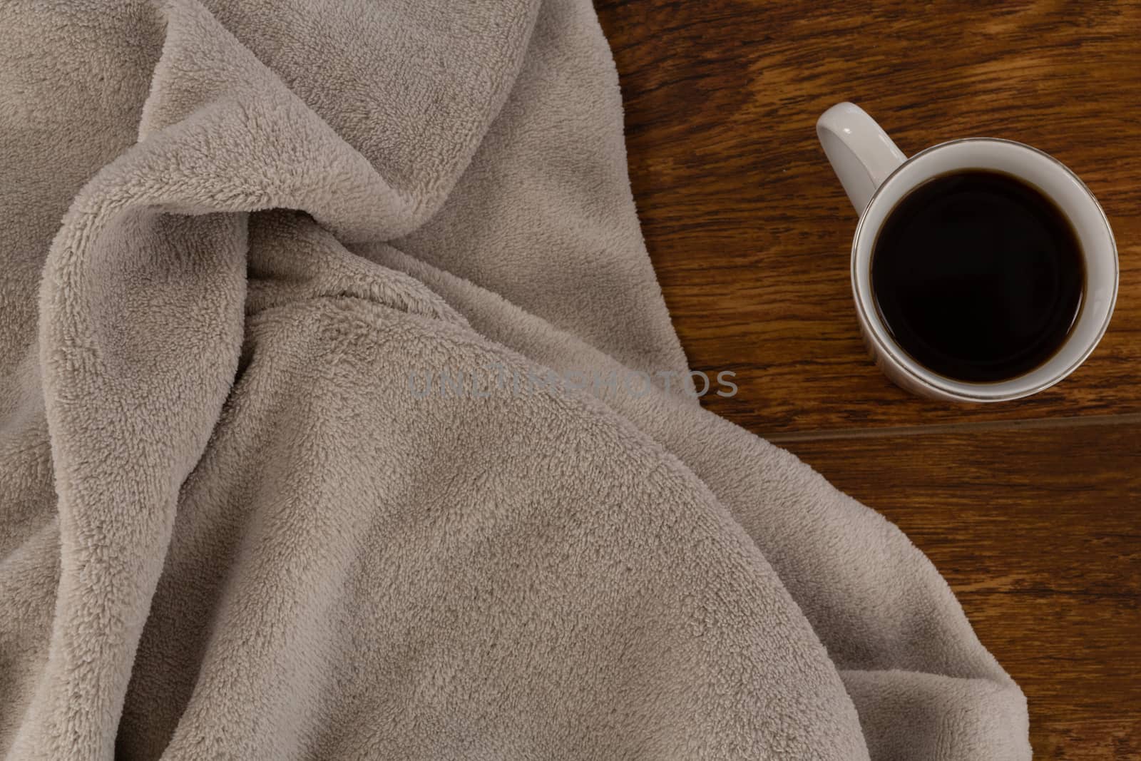 Close-up of blanket and black coffee on wooden background