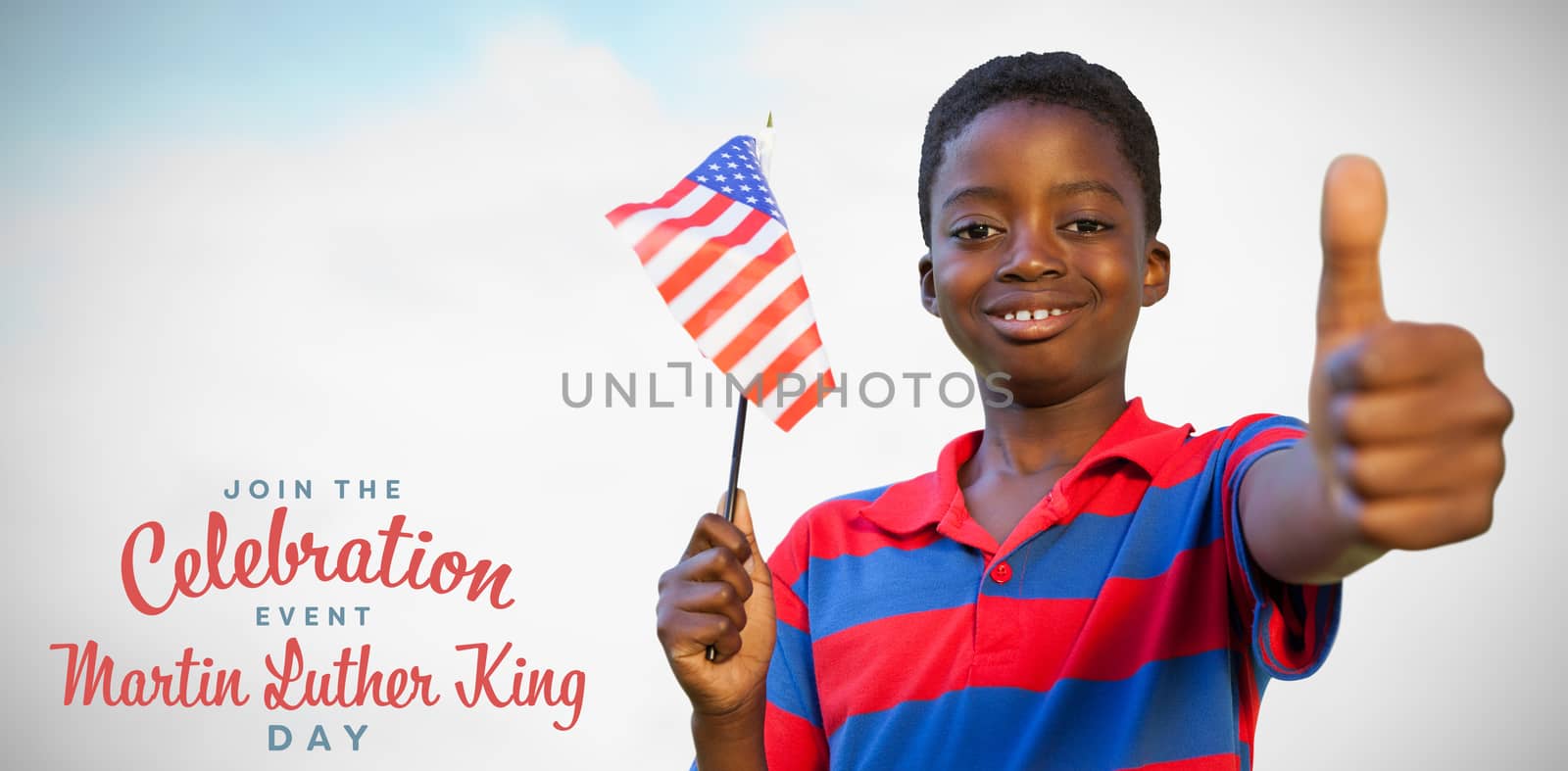 Little boy waving american flag against blue sky with clouds 