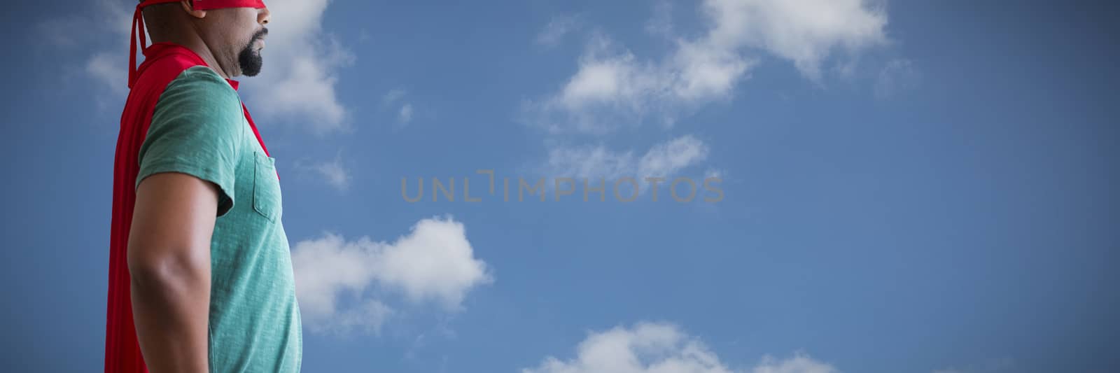 Man pretending to be a superhero against low angle view of sky