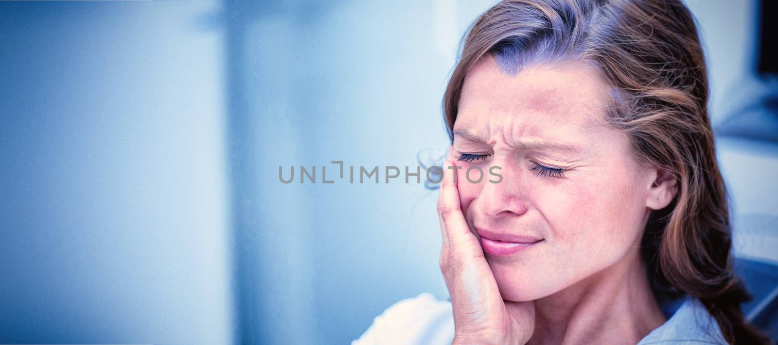 Unhappy woman having a toothache  in dental clinic
