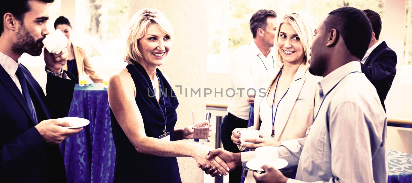 Business executives interacting with each other while having coffee at conference center