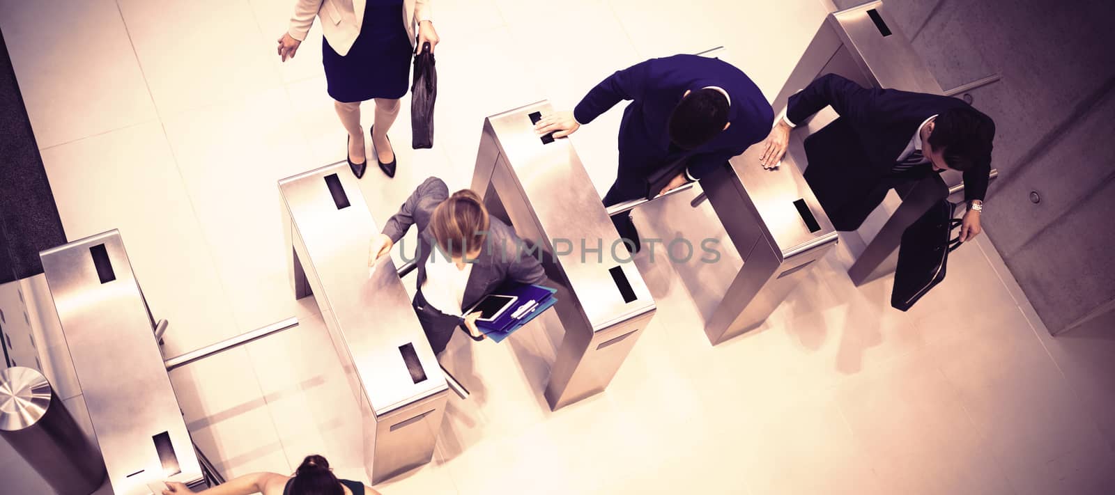 Top view of business executives passing through turnstile gate