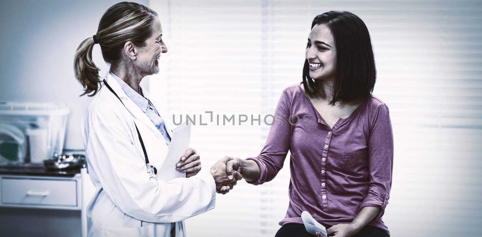 Female doctor shaking hands with patient in clinic