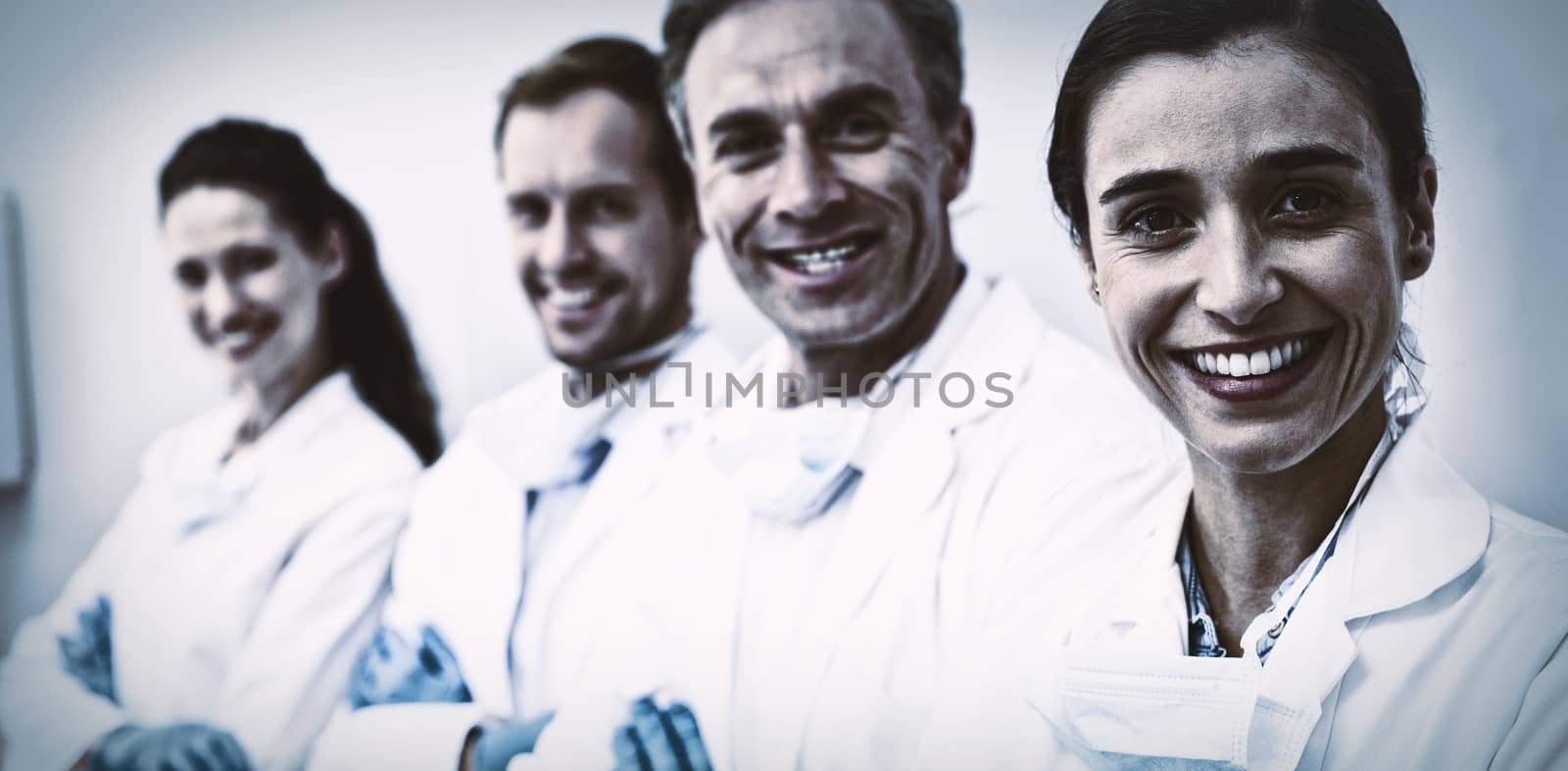 Portrait of smiling dentists standing with arms crossed in dental clinic