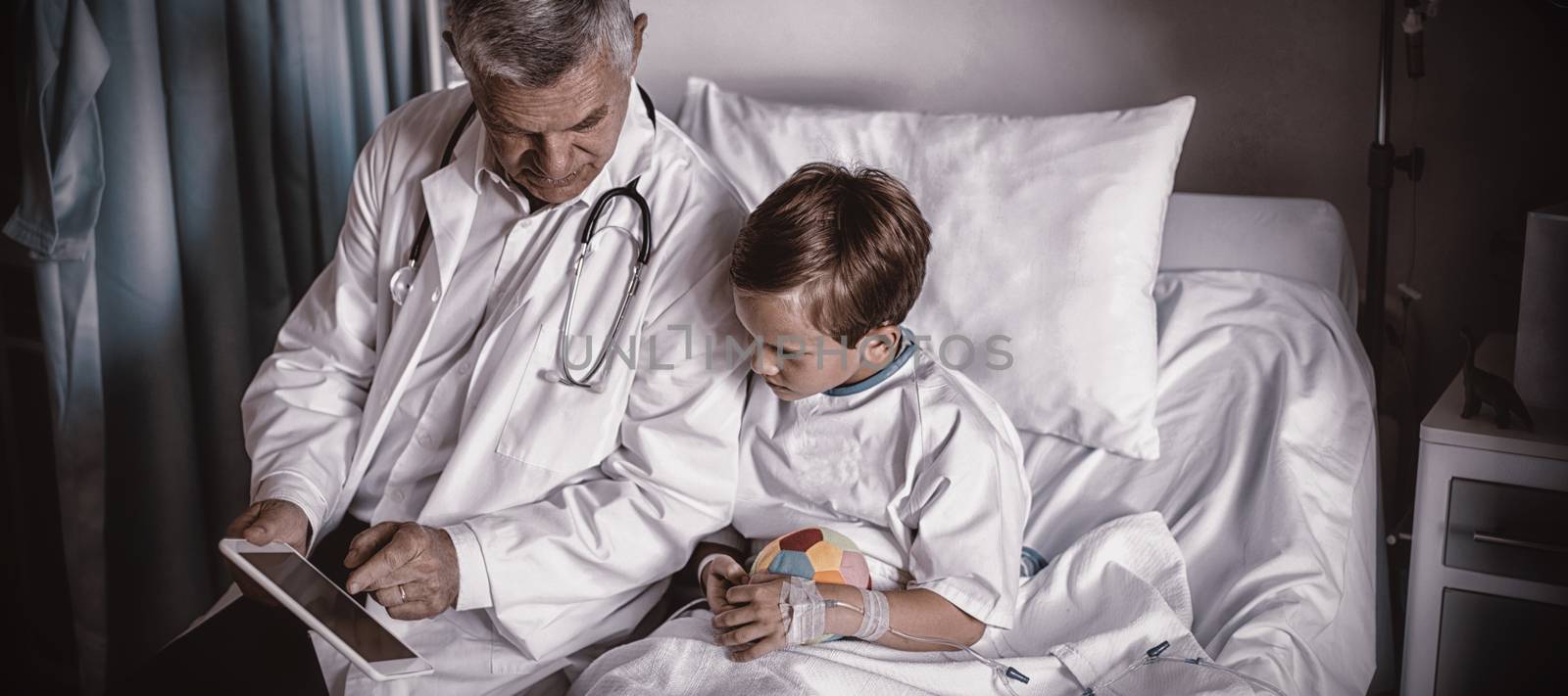 Doctor showing medical report in digital tablet to patient in hospital