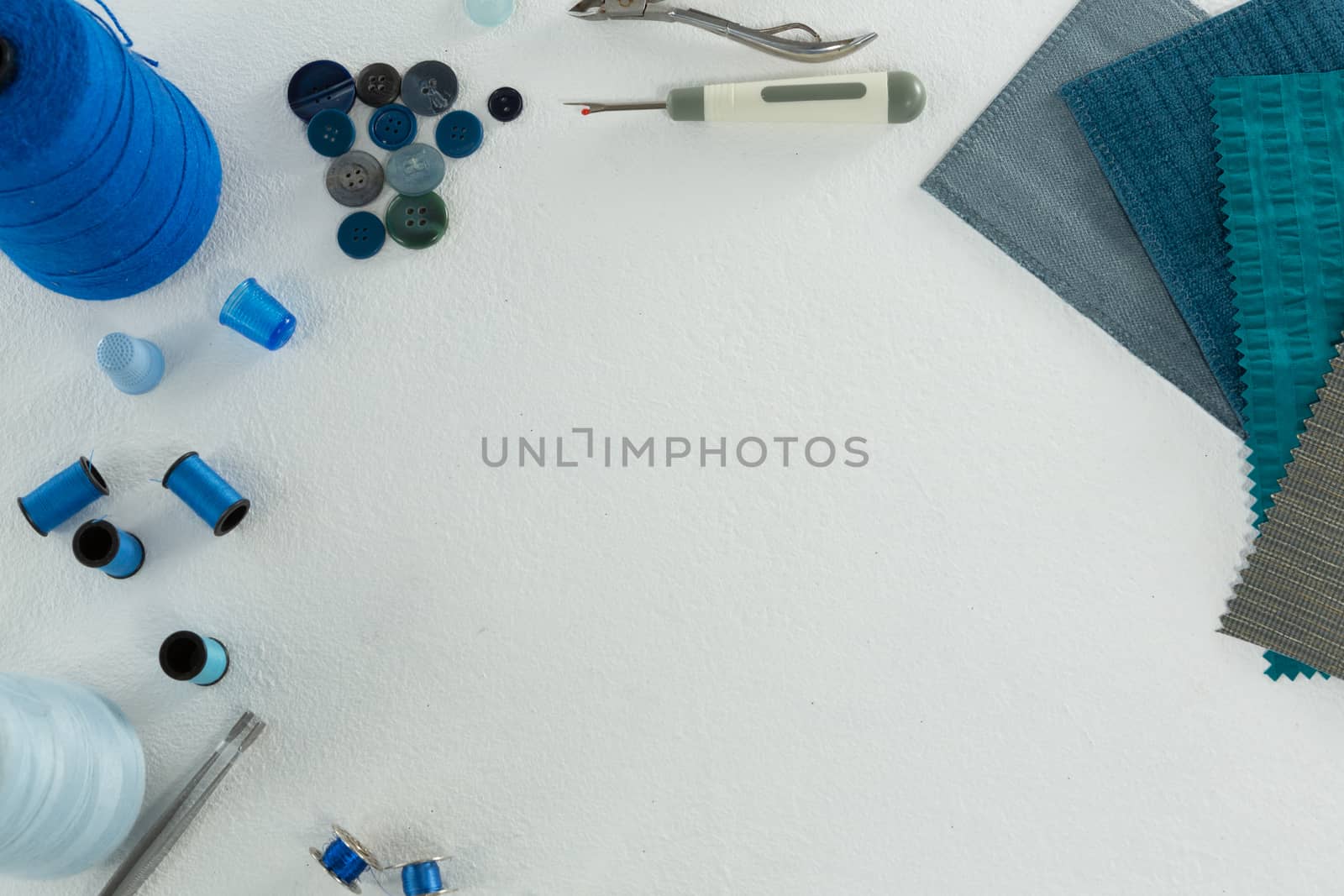 Overhead of thread rolls and various tools on white background