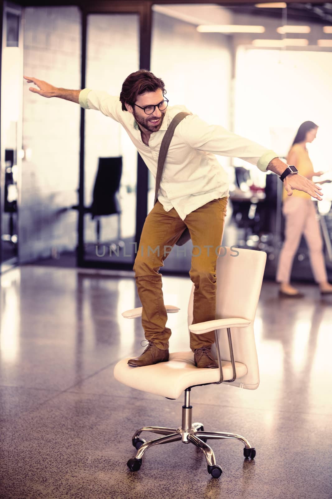 Male business executive standing on chair by Wavebreakmedia