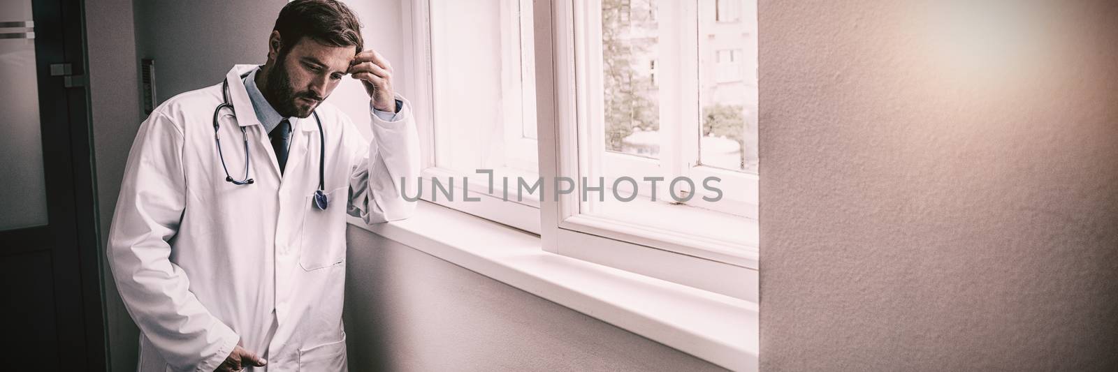 Sad doctor standing in hospital corridor