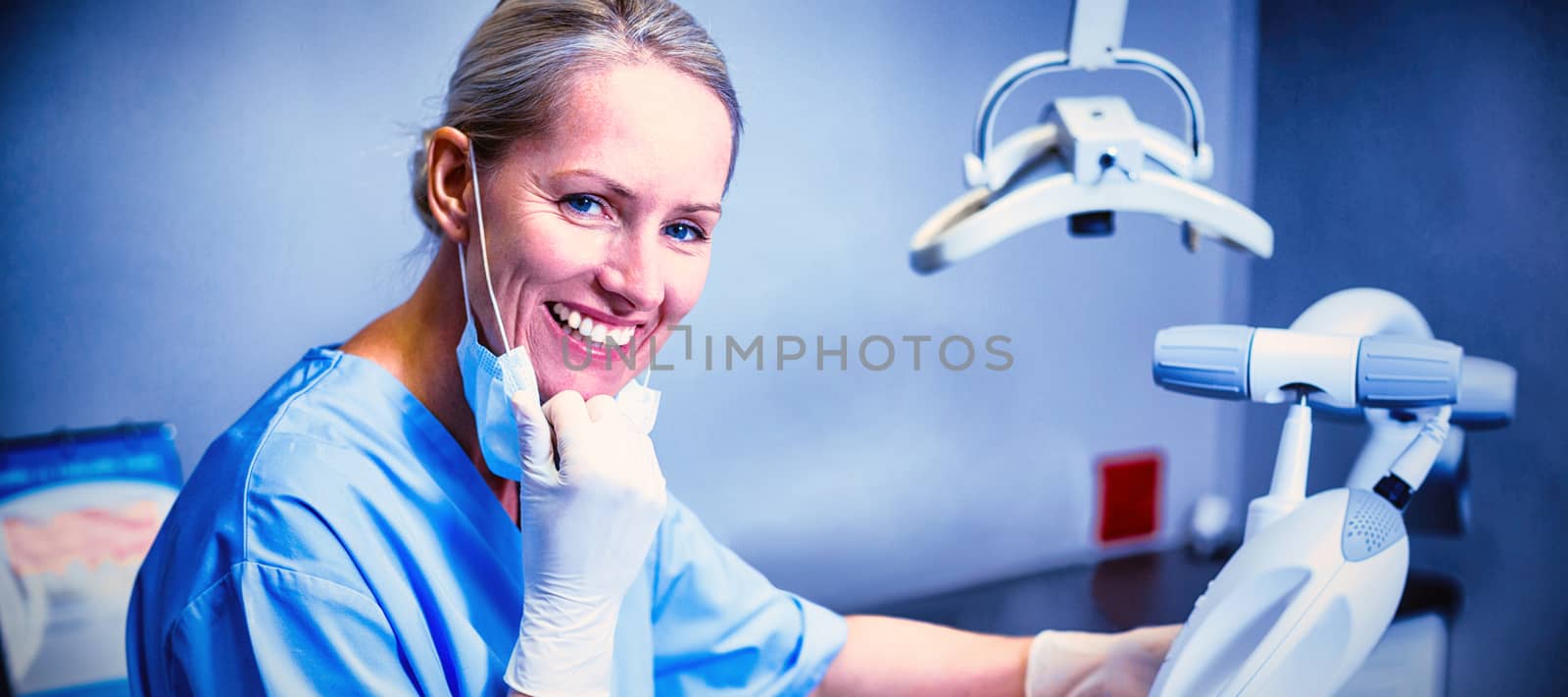 Dental assistant examining young patient mouth by Wavebreakmedia