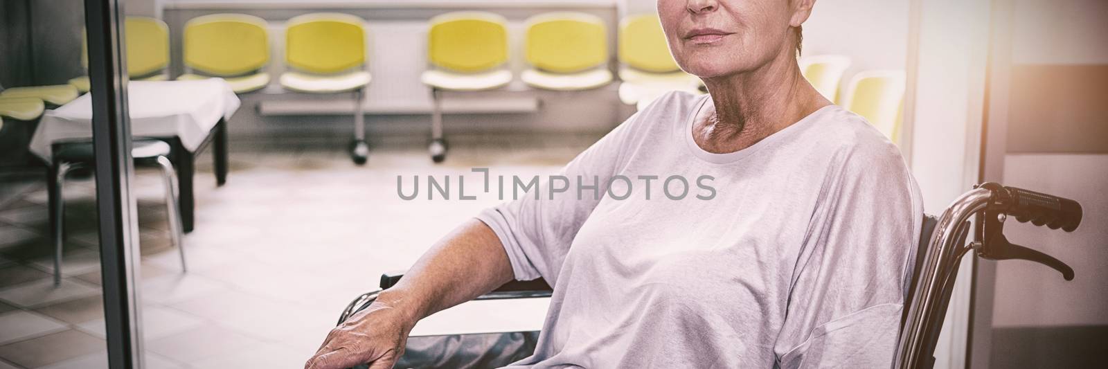 Portrait of sad senior patient sitting on a wheelchair in hospital