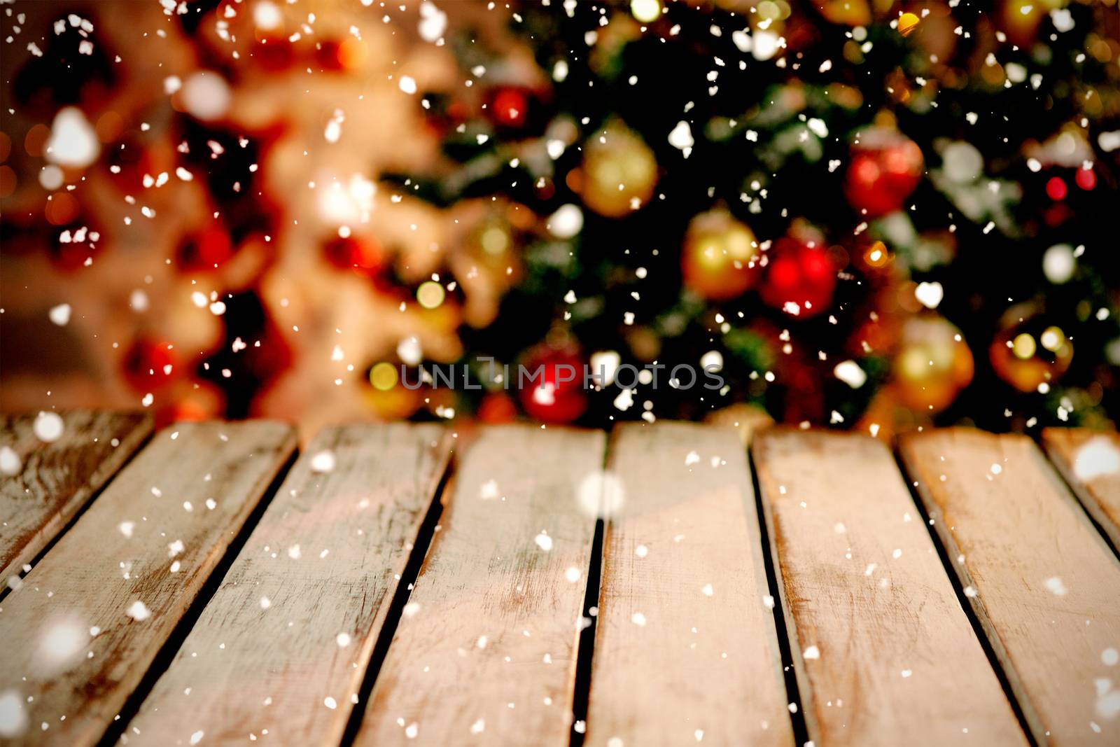 Snow falling against unfocused christmas tree with copy space