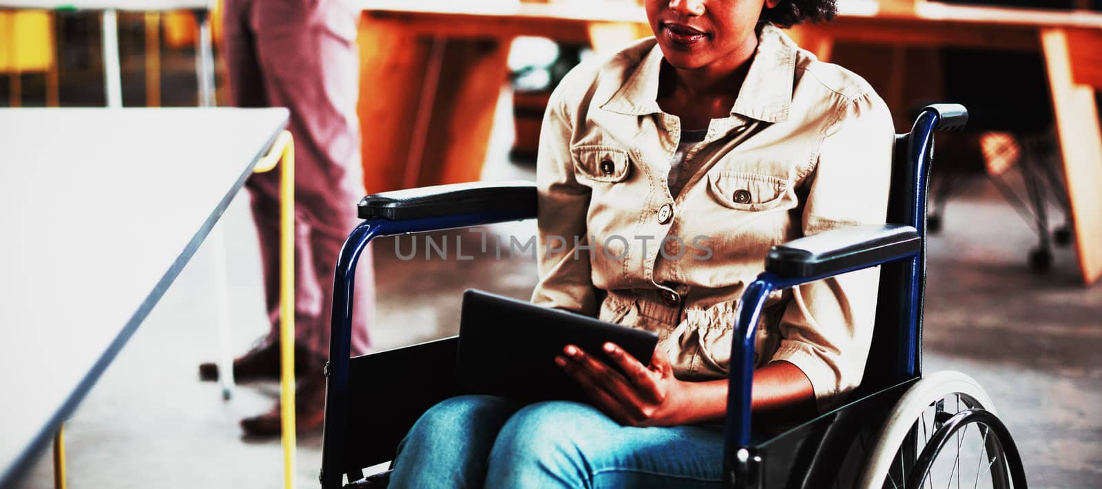 Disabled business executive in wheelchair using digital tablet by Wavebreakmedia