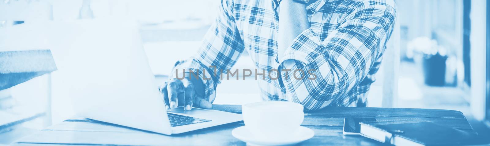 Man using laptop in cafeteria