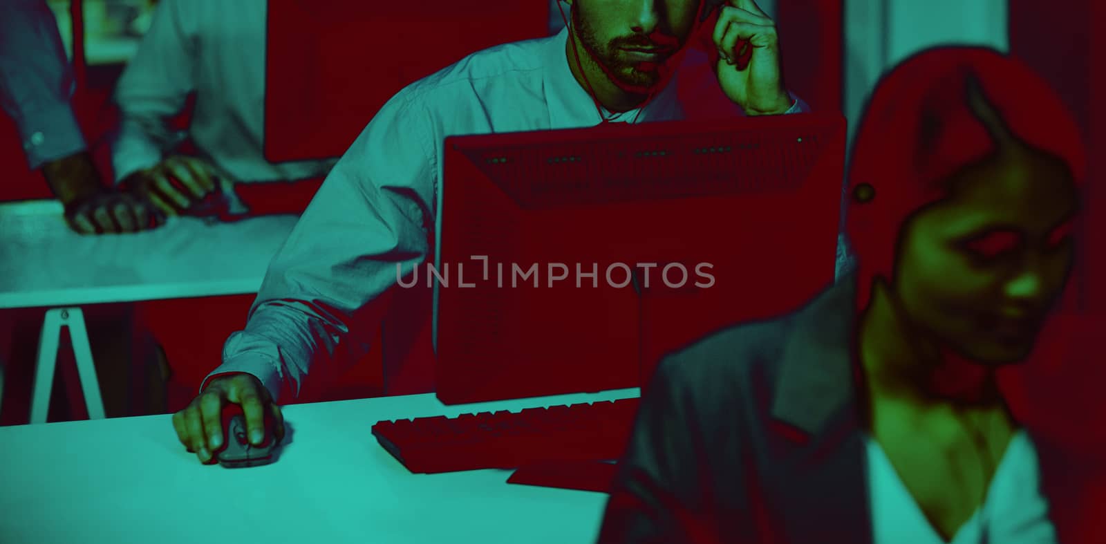 Businessman with headsets using computer in office at night