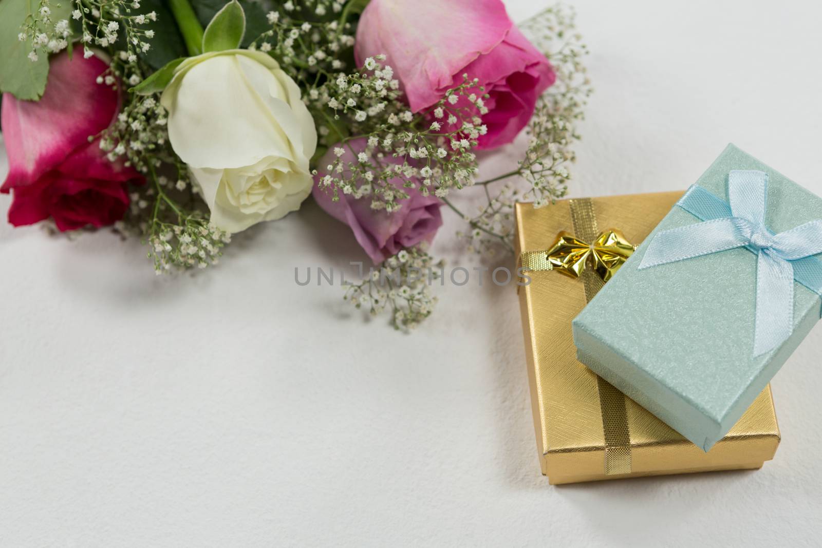 Close-up of flower bouquet and gift on white background