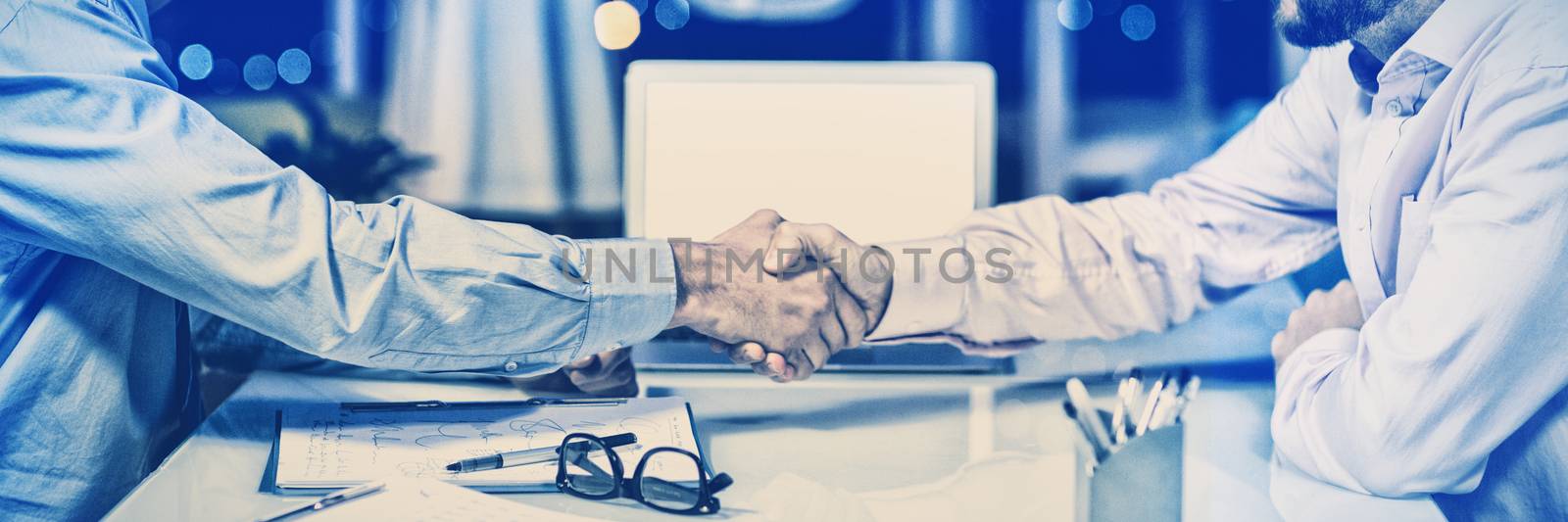 Businessmen shaking hands in conference room at office