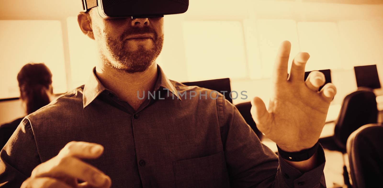 Businessman using virtual reality simulator while sitting at officr