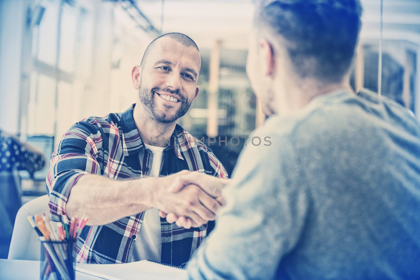 Confident business people shaking hands in creative office