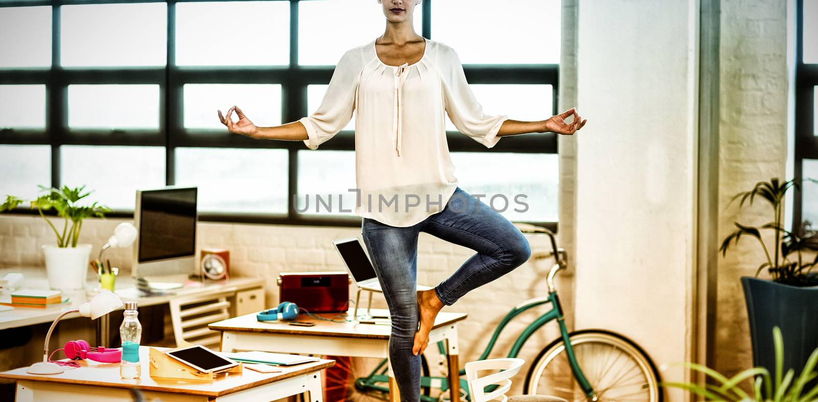 Female business executive performing yoga in office