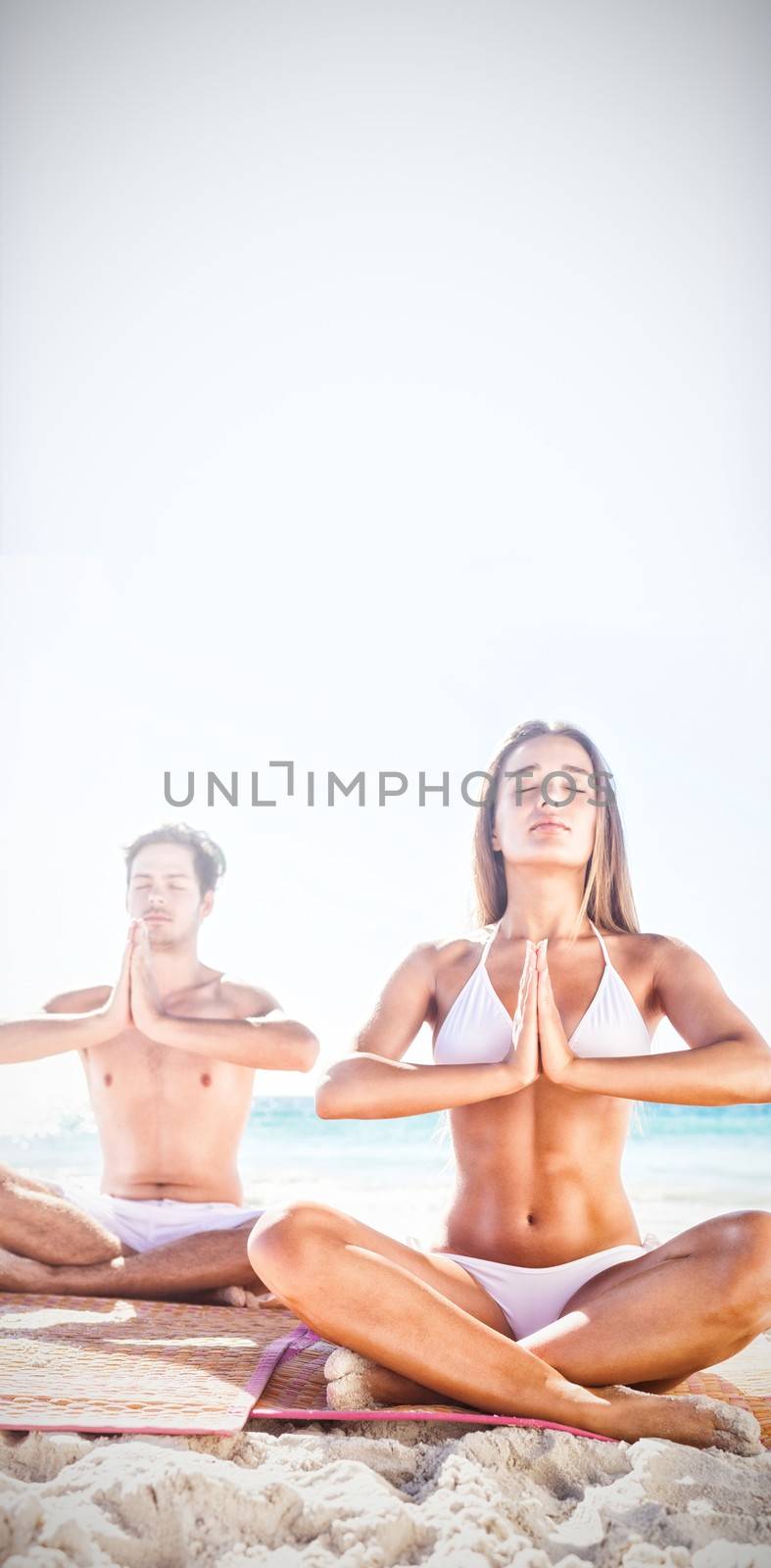  Happy couple doing yoga on the beach