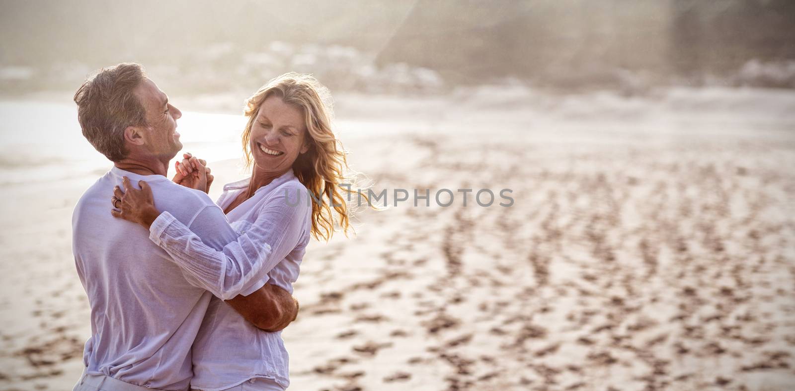 Happy mature couple having fun together at beach