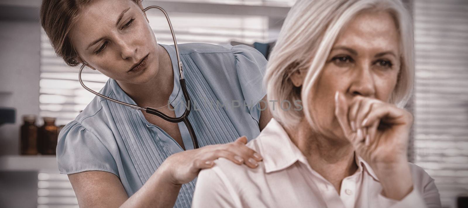 Doctor examining coughing patient by Wavebreakmedia